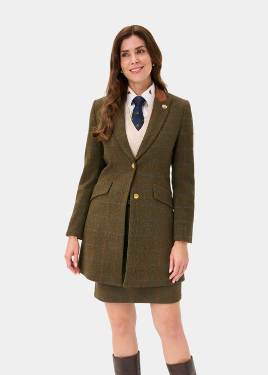 Woman models Combrook Ladies Tweed Water Repellent Mid-Thigh Coat in Willow, smiling against a white background.