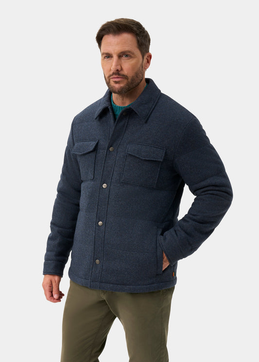 A man wearing a Richmond Men’s Knitted Quilted Shacket In Navy over a green sweater and olive trousers.
