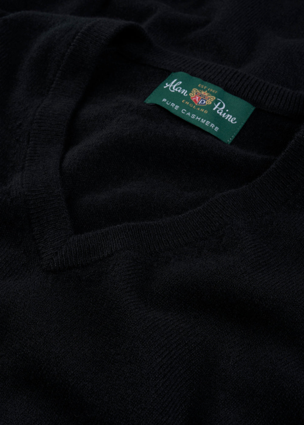 Close-up of a Haddington Pure Cashmere V-Neck Jumper in black, regular fit, with visible Alan Paine label.