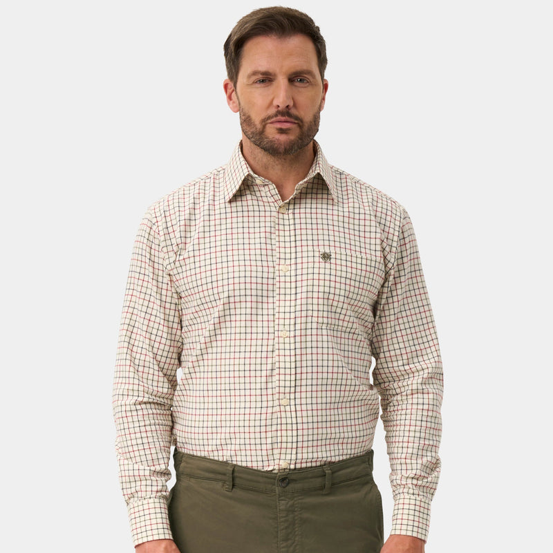 A man modeling a beige and white checkered long-sleeve button-down shirt paired with olive green trousers and dark brown dress shoes, set against a plain light gray background.