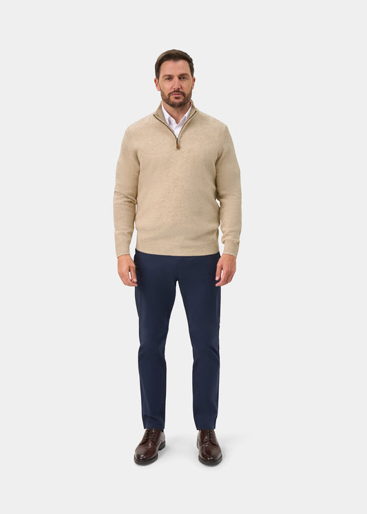 Alan Paine Sutherland lambswool quarter zip jumper in linen beige worn by a man with navy trousers and brown shoes