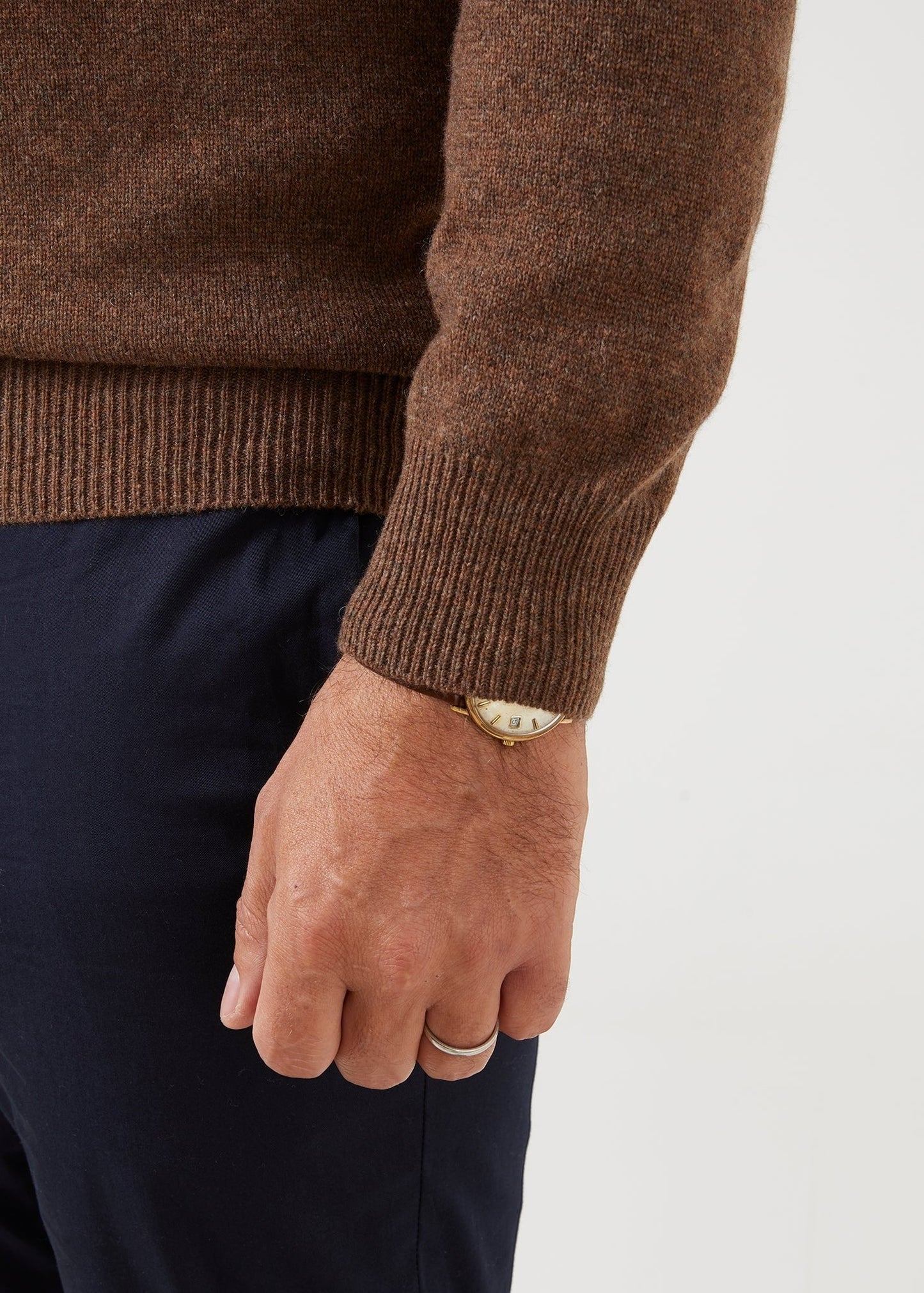 Alan Paine tobacco lambswool jumper featuring a ribbed cuff and classic fit, worn with navy trousers.