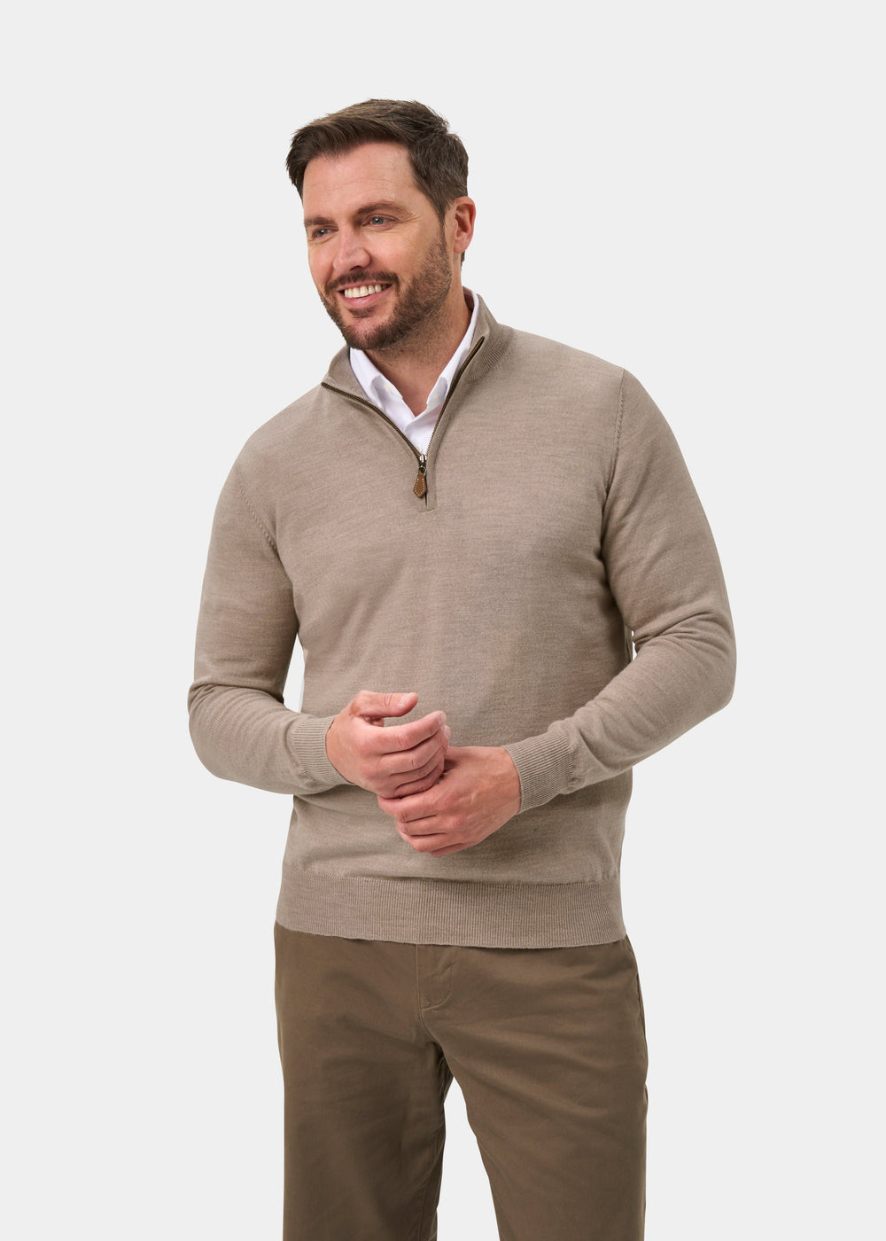Man smiling in Barton Merino Wool Quarter Zip Jumper in Cobble over white shirt, brown pants, on white background.