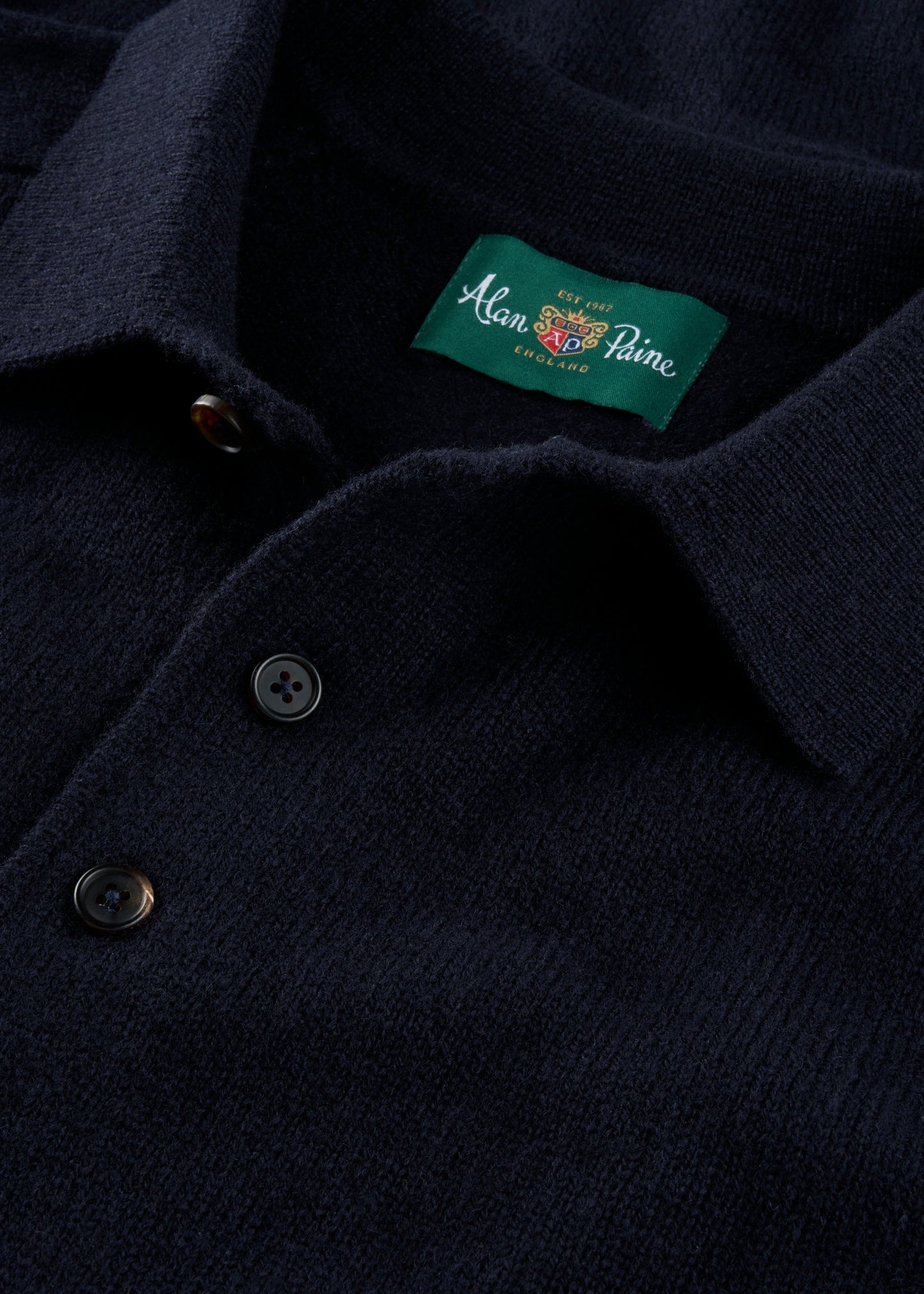 Navy blue polo shirt with a brand label on the chest.