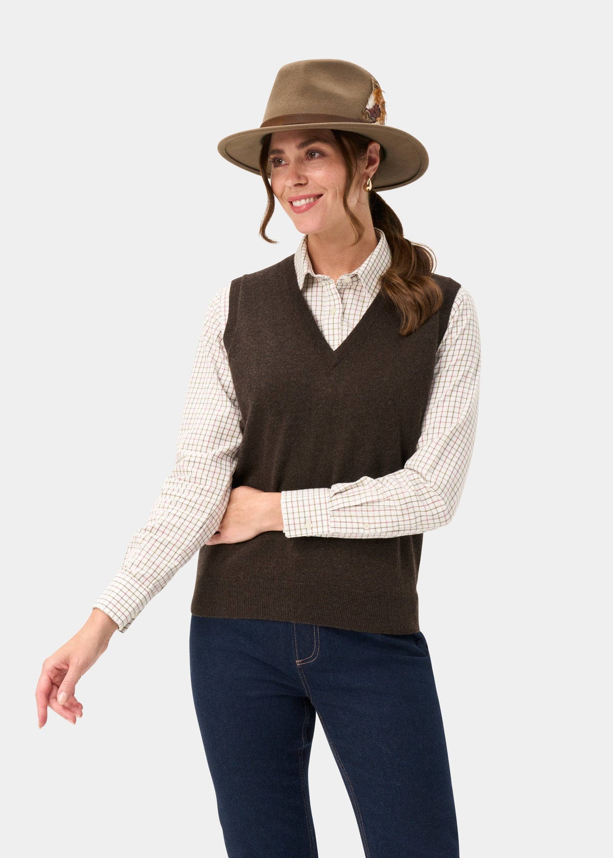 Smiling woman in a brown hat, checked shirt, and Erin Wool & Cashmere V-Neck Slipover In Walnut against light background.