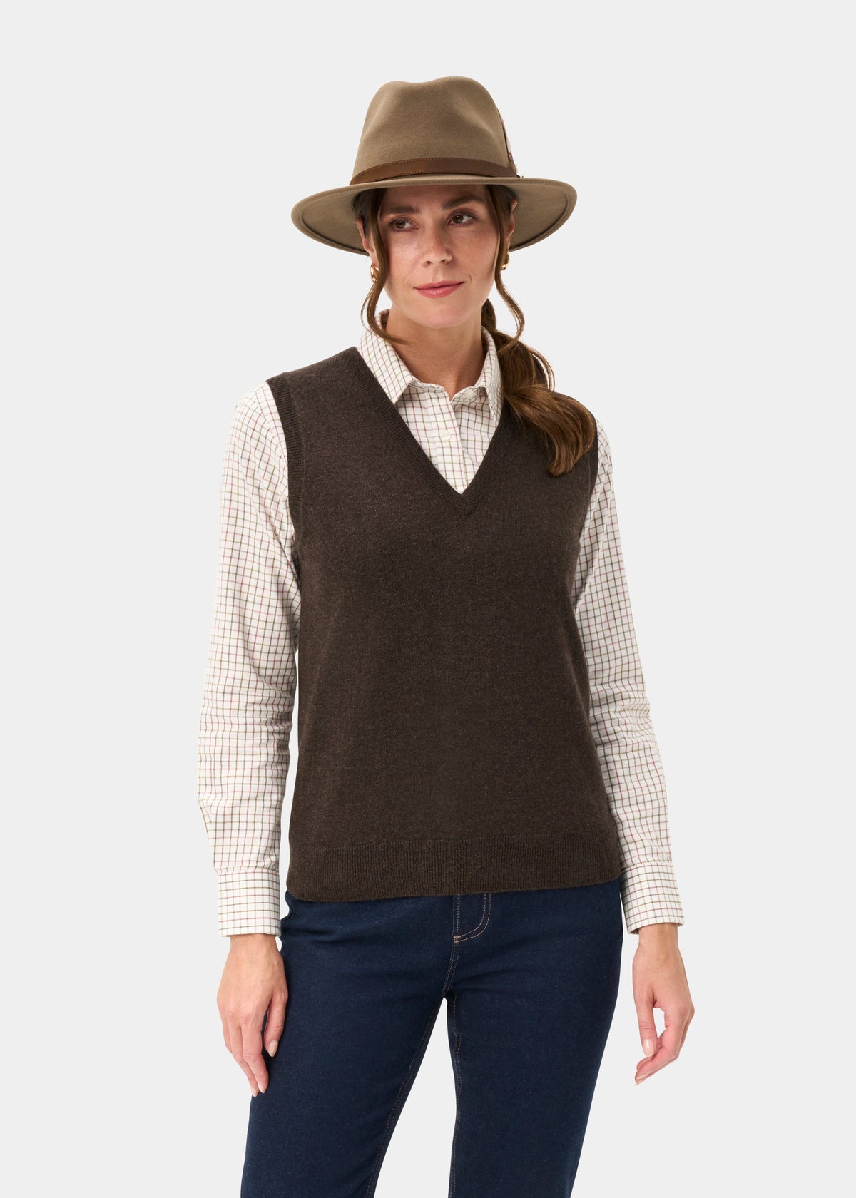 Woman wears the Erin Wool & Cashmere V-Neck Slipover in Walnut over a plaid shirt, with hat and dark jeans.