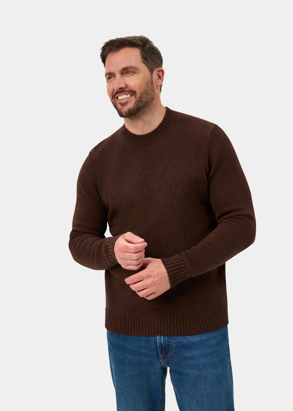 Bearded man in Kinnadie Supersoft Shetland Wool Crew Neck Jumper (Coffee, Regular Fit) and blue jeans, smiling.